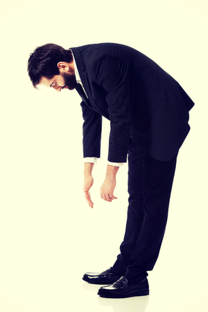 Young handsome businessman bending down.の写真素材