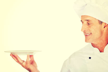 Restaurant chef holding white porcelain plateの写真素材