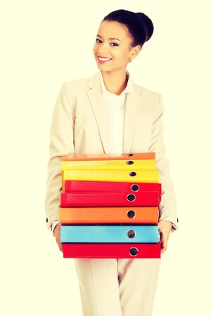 Happy businesswoman holding heavy bidners.の写真素材