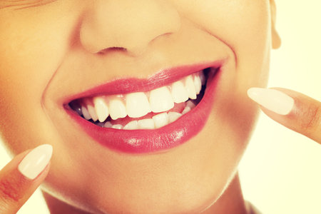 Beautiful african woman pointing to teeth.