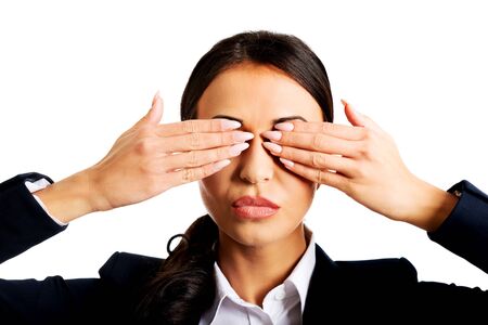 Young businesswoman covering eyes with hands.の写真素材