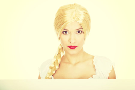 Woman wearing traditional Bavarian dress holding empty banner.の写真素材