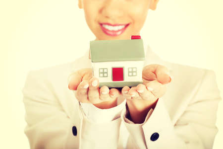 African businesswoman holding small house on palm.の写真素材