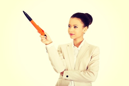 African businesswoman pointing up with big pen.の写真素材