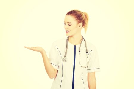 Smiling medical doctor woman with open hand.の写真素材