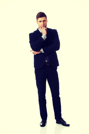 Successful thoughtful businessman with finger under chin.の写真素材