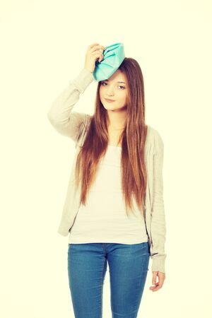 Teen woman with headache and ice bag.の写真素材