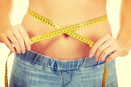 Slim caucasian woman measuring her waist.の写真素材