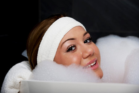 Beautiful bathing woman relaxing in bathtub.