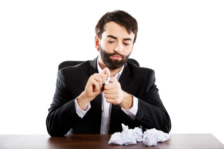 Young worried businessman crushing sheets.の写真素材