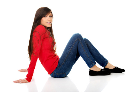 Relaxing student woman sitting on the floor.の写真素材