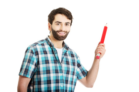 Young happy man holding oversized red pencil.の写真素材
