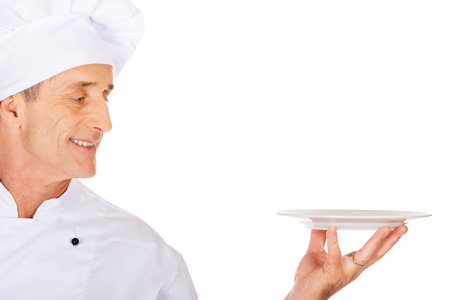 Restaurant chef holding white porcelain plateの写真素材