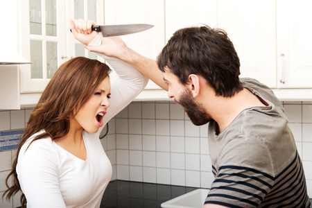 Young angry couple arguing and pushing each other at home.の写真素材