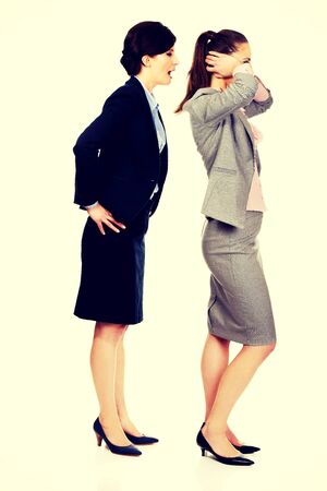 Businesswoman covering ears from her angry partner.の写真素材