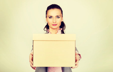Sad businesswoman carrying box after loosing job.