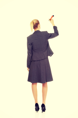 Attractive businesswoman writing with oversized pen.の写真素材