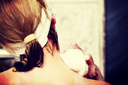 Beautiful bathing woman cleaning herself with sponge.の写真素材