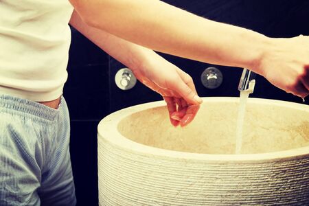 Woman cleaning hands in bathroom.の写真素材