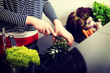 Woman in the kitchen preparing some healthy food.の写真素材
