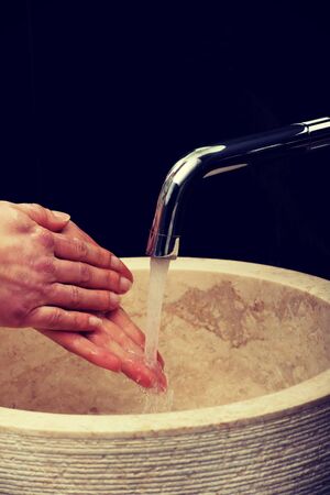 Woman cleaning hands in bathroom.の写真素材