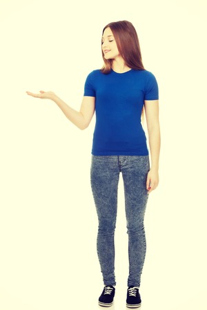 Teenage woman showing something on open hand.の写真素材