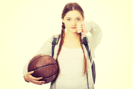 Teenager with basketball and thumbs down.