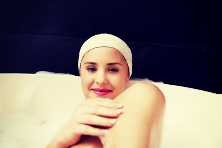 Beautiful bathing woman relaxing in bathtub.