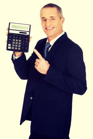 Mature businessman pointing on calculator.の写真素材