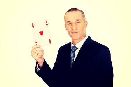 Smart mature business man with red ace card.の写真素材