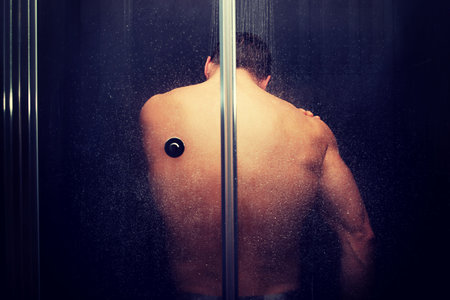 Handsome muscular man at the shower.