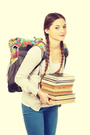 Teenage woman with backpack and heavy books.の写真素材