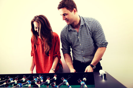 Friends having fun together playing table football.の写真素材