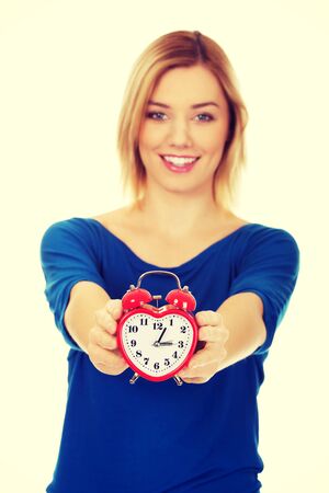Young happy woman holding alarm clock.の写真素材
