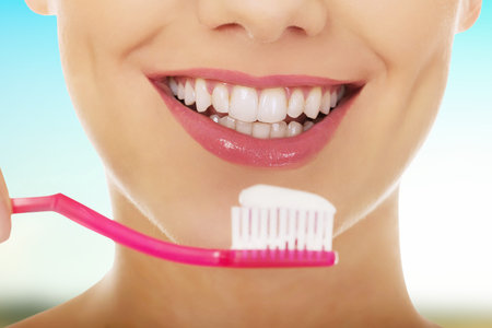Young woman holding a toothbrush.