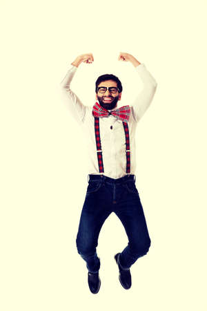 Funny man wearing suspenders jumping up.の写真素材