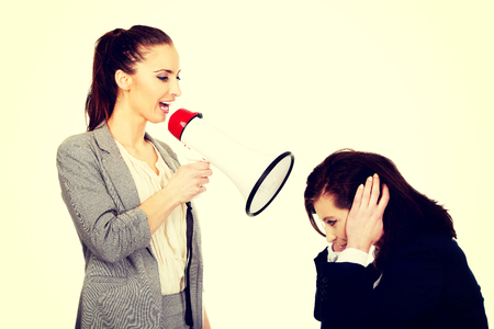 Businesswoman screaming with megaphone on her friend.の写真素材