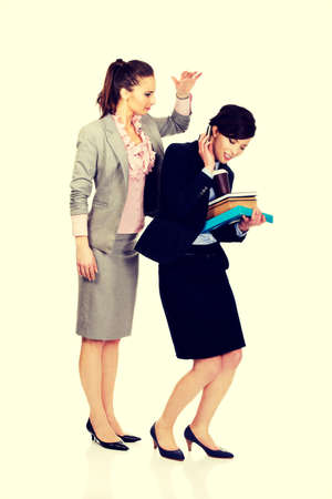 Businesswoman try to get attention from her busy partner.の写真素材