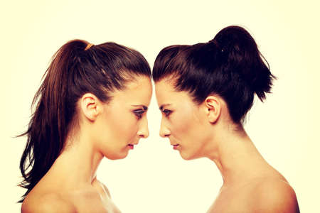 Two attractive sisters standing face to face.の写真素材