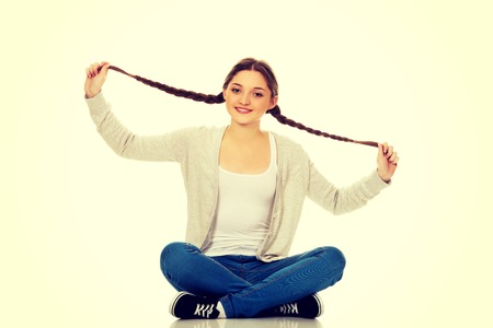 Beautiful teen woman sitting cross legged.の写真素材