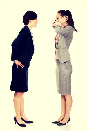 Businesswoman covering ears from her angry partner.の写真素材