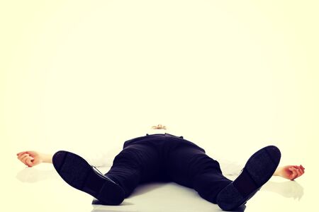 Young exhausted businessman lying on the floor.の写真素材
