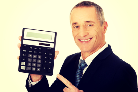 Mature businessman pointing on calculator.の写真素材