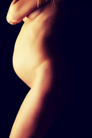 Woman touching her growing pregnant bellyの写真素材