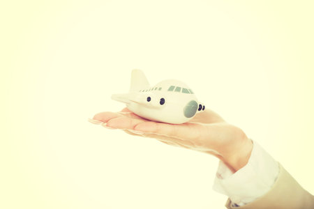 Business woman hand holding a toy plane.
