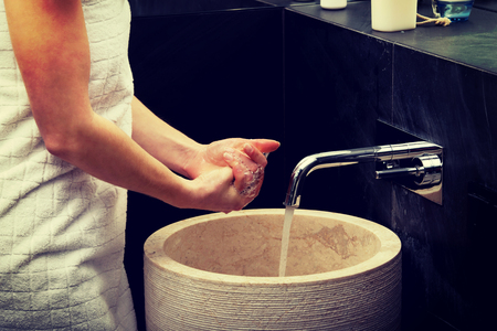 Woman cleaning hands in bathroom.の写真素材