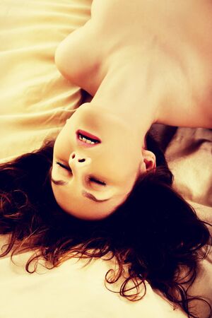 Young naked woman in bed getting orgasm.の写真素材