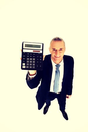 Happy mature businessman holding a calculator.の写真素材