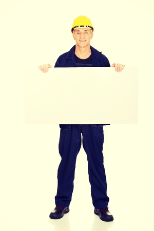 Full length happy worker presenting empty banner.の写真素材