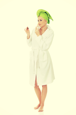 Woman in towel turban smelling parfume.の写真素材